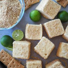 limes and graham crackers are arranged on a baking sheet next to a bowl of sugar