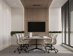 an empty conference room with two desks and a flat screen tv on the wall