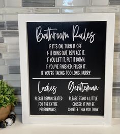 a bathroom rules sign on a shelf next to a potted plant