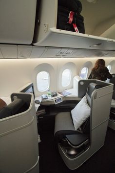 the inside of an airplane with people sitting on seats