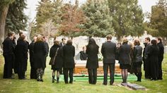 a group of people standing in front of a cemetery