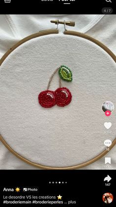 an embroidery project with two cherries on it