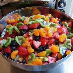 a metal bowl filled with lots of fruit