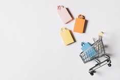 an empty shopping cart next to small paper tags on a white background with copy space in the middle