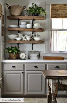 a kitchen with gray cabinets and shelves filled with dishes