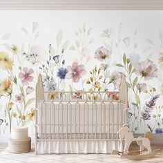 a baby crib in front of a floral wall mural