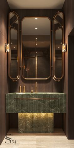 an elegant bathroom with gold fixtures and green marble countertop, along with two mirrors on the wall