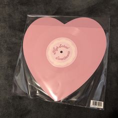 a pink heart shaped vinyl record in a package