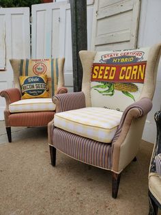 two chairs sitting next to each other in front of a white building with a seed corn sign on it