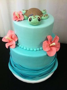 there is a blue cake with flowers on the side and a bird on top,