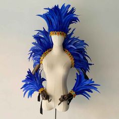 a white mannequin with blue feathers on it's head