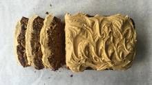 three slices of cake with peanut butter frosting sitting on top of parchment paper next to each other