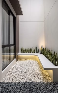 a white bench sitting next to a window filled with plants