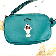 This Stylish Crossbody Bag By Coach Is A Must-Have For Any Fashion-Savvy Woman. The Bag Features An Eye-Catching Green Handle/Strap And Blue Hardware That Perfectly Complements The Cream-Colored Leather Exterior. The Bag's Interior Is Lined With A Gorgeous Shade Of Green That Adds To Its Appeal. The Bag's Compact Size Makes It Perfect For Carrying All Your Essentials Without Weighing You Down. It's Ideal For Everyday Use Or For Special Occasions. The Coach Blue Green Leather Ice Cream Sundae Cro Coach Crossbody Shoulder Bag With Cell Phone Pocket, Coach Crossbody Bag With Cell Phone Pocket, Coach Crossbody Mobile Phone Bag, Coach Shoulder Bag With Cell Phone Pocket, Coach Mobile Phone Crossbody Bag, Coach Satchel Mobile Phone Bag, Coach Mobile Phone Pouch Bag, Coach Pouch Bag With Cell Phone Pocket, Coach Shoulder Bag With Mobile Phone Pocket For On-the-go