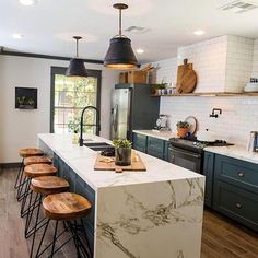 a kitchen with marble counter tops and stools in front of an island that's surrounded by wood flooring