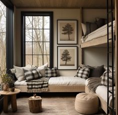 a bedroom with bunk beds, pillows and pictures on the wall next to it's windows