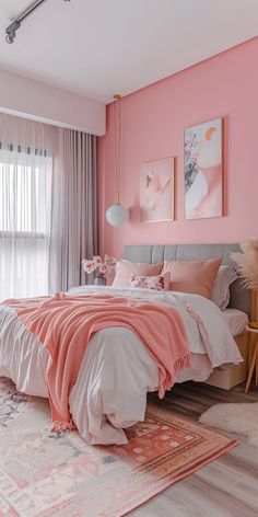 a bedroom with pink walls and white bedding, rugs and artwork on the wall