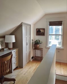 a room with a desk, chair and window in the corner next to a dresser