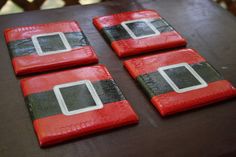 three red and black coasters sitting on top of a table