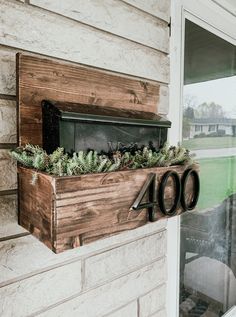 a wooden box with plants in it is on the side of a house that reads forty