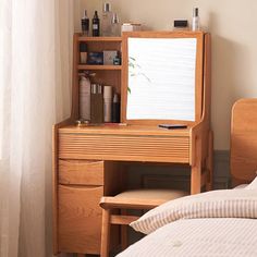 a bedroom with a bed, desk and mirror next to a window in the room