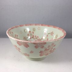 a pink and white bowl with flowers on it