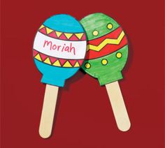 two wooden spoons with painted eggs on them and the words morah written in white