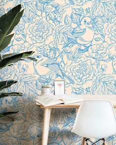 a table with a book and some plants on it in front of a wallpaper