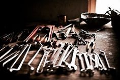 there are many wrenches and other tools on the table next to each other,