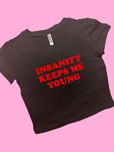 Insanity Keeps Me Young SNUG FIT Crop Top | Crop Top | Graphic Top | Gift For Her | Y2K  Tee | Y2K crop top | Gift for friend | Baby Tee Comfy Top to Lounge in! Actual item may be lighter/darker than pictured. M A T E R I A L S - SNUG FIT - 100% RING SPUN COTTON - Shoulder Taping S I Z I N G - Size chart is available on our listing photos. S H I P P I N G  &  P R O D U C T I O N  T I M E - Production Time is 5 Business Days. (May be delayed during the Holiday Season) - Shipping Time is 2-6 Busin Y2k Style Text Print Crop Top T-shirt, Y2k Style Crop Top T-shirt With Text Print, Y2k Text Print Cropped T-shirt, Y2k Cropped T-shirt With Slogan, Fitted Y2k Cropped T-shirt With Slogan, Funny Crop Tops, Goofy Shirt, Sarcastic Clothing, Funky Shirts