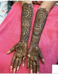 two hands with henna tattoos on them