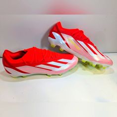 a pair of red and white soccer shoes