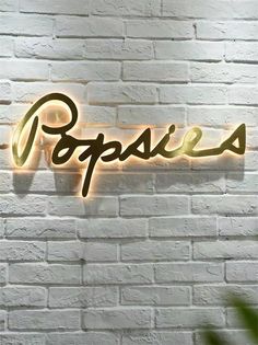 a brick wall with a neon sign that says poppies