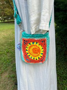 Vibrant summer bag in playful shades of orange, yellow, and turquoise! Features a trendy sun and moon design on both sides, accented with a splash of turquoise and coordinating blue lining. The Adjustable strap( up to 44") is also lined with fabric prevent stretching. At approx 8" x 8" it's perfect size for all your essentials (phone, wallet, keys, etc). A 1.5" flat bottom allows it it box up nicely, and the magnetic snap closure adds convenience. Simply spot clean and lay flat to dry. Made with cotton and acrylic yarns. Sun And Moon Design, Grocery Market, Yellow And Turquoise, Coiled Rope, Rope Decor, Market Tote Bag, Crochet Clothing And Accessories, Coupon Organization, Summer Bag