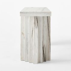 a white marble side table with three columns