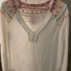 White Cotton Blouse With Multi-Colored Embroidered Detail On Collar And Back. Brand New, Never Worn. White V-neck Blouse With Intricate Embroidery, White V-neck Top With Intricate Embroidery, White Long Sleeve Tops With Floral Embroidery, White Floral Embroidery Long Sleeve Tops, White Long Sleeve Tops With Intricate Embroidery, White Embroidered Long Sleeve Top, White Long Sleeve Embroidered Top, White Casual Top With Embroidered Neckline, Casual White Tops With Embroidered Neckline