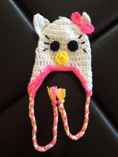 a crocheted hello kitty hat with a pink bow and yellow earflap