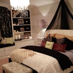 a bedroom with a bed, dressers and chandelier