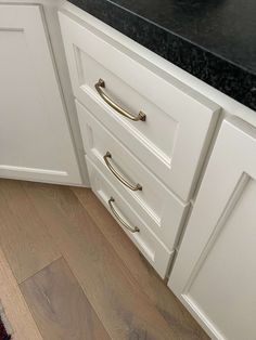 a kitchen with white cabinets and black counter tops is pictured in this image from the bottom