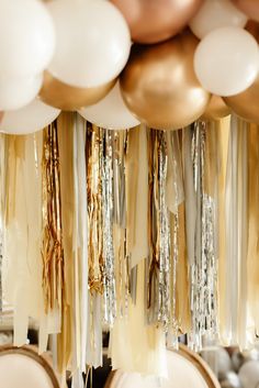 gold and white balloons hanging from the ceiling