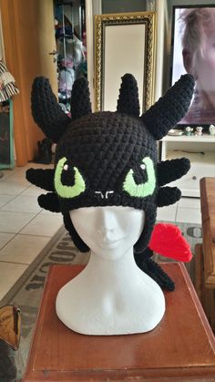 a crocheted black cat hat on top of a mannequin head