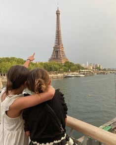 two girls are looking at the eiffel tower