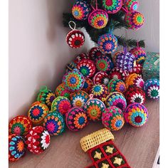 there are many crocheted ornaments on the floor next to a christmas tree and other decorations