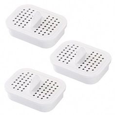 two white graters sitting next to each other on top of a white surface