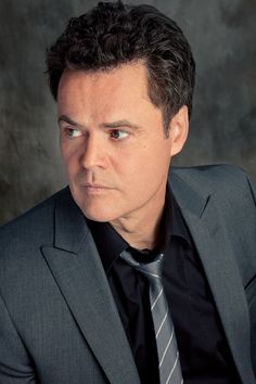 a man in a suit and tie looking at the camera with an intense look on his face