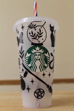 the starbucks cup is decorated with black and white designs, including an image of a witch