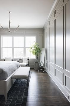 a bedroom with white walls and wood floors