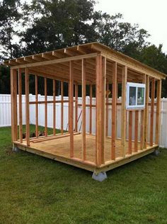 a small wooden shed sitting in the grass