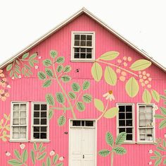 a pink house with flowers painted on the side