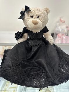 a teddy bear dressed in a black dress